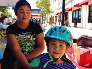 Greenfield girl helping little ones learn bike helmet fit 2012